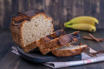 Homemade banana bread with cinnamon on a wooden background, close up