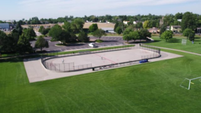A drone pull focus of a summer rollerblade hockey game.