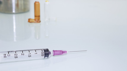 medical syringe and needle on doctor jar and ampule background