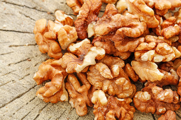 Walnuts on brown wooden background.