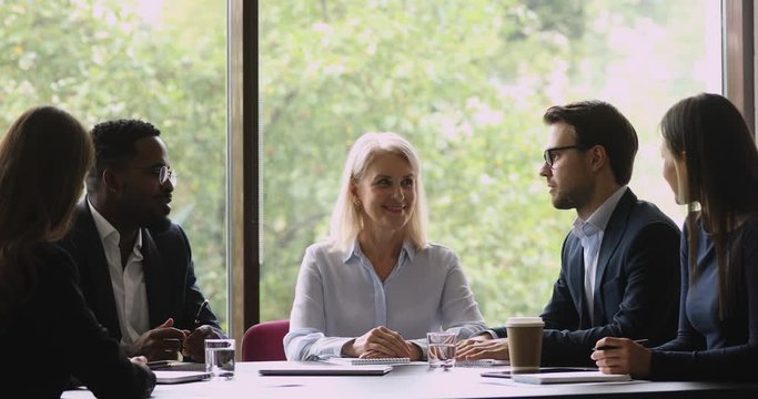 Happy diverse businessmen partners shake hands at group negotiations