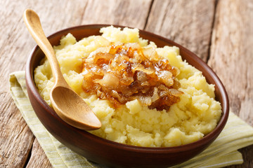 Organic boiled potatoes with caramelized onions close-up on a plate. horizontal