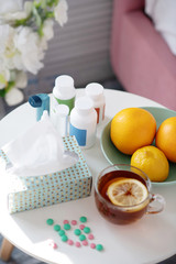 Top view of medications standing on the table near tea and oranges