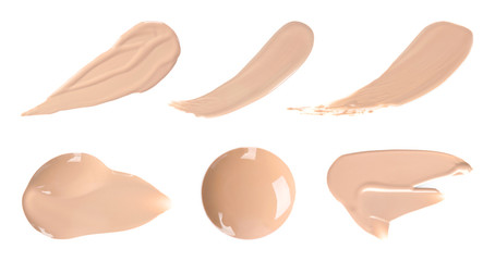 Set with samples of liquid foundation on white background, top view