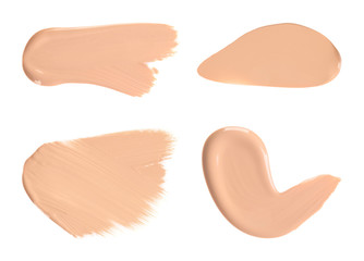 Set with samples of liquid foundation on white background, top view
