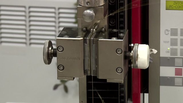 Strength test of a wire sample. Rollers of tension of the explosive car. Tensile machine of steel wire