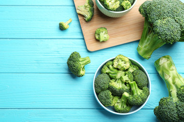 Flat lay composition of fresh green broccoli on blue wooden table, space for text