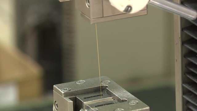 Strength test of a wire sample. Rollers of tension of the explosive car. Wire breakage during strength test.