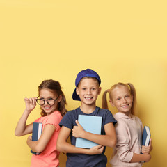 Little children with books on yellow background. Reading concept