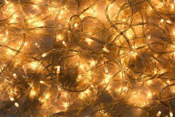 Glowing Christmas lights on white wooden background, top view