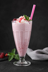 Tasty fresh milk shake in glass on black table
