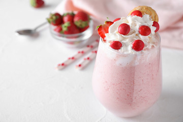 Tasty strawberry milk shake in glass on white table. Space for text