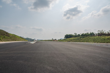 Perspective view of new asphalt road and sky in modern city suburb