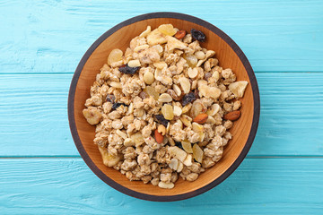 Bowl with healthy granola on light blue wooden table, top view