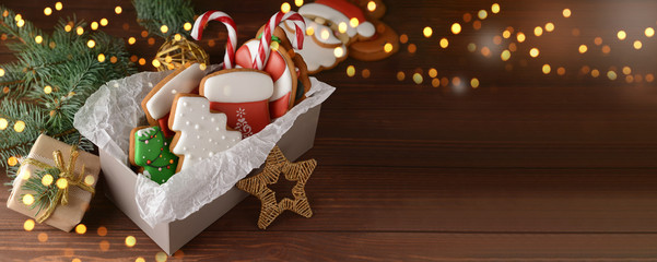 Box with tasty Christmas cookies on wooden table