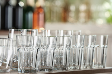 Empty glasses on wooden table against blurred background
