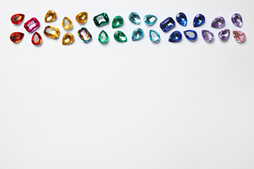 Different beautiful gemstones on white background, top view