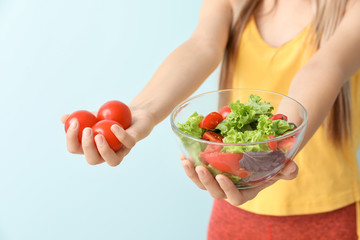 Woman with healthy vegetable salad on light background, closeup. Diet concept