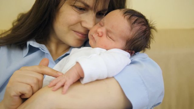 Portrait of mother face and newborn baby, mother holding and caressing child
