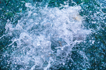 Spray in the blue water of the sea