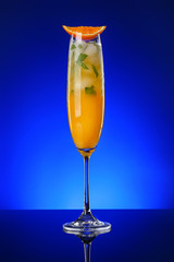 Glass of tasty cocktail on dark color background