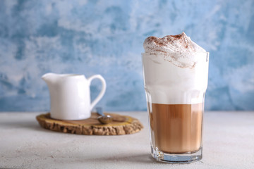 Glass of tasty frappe coffee on table