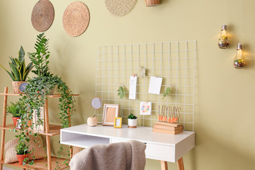 Comfortable workplace with mood board near color wall