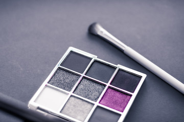 Eyeshadow palette and make-up brush on graphite background, eye shadows cosmetics product for...