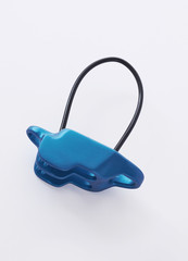 Vertical photo. Isolated photo of climbing equipment - blue colored part of carabiner