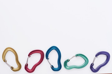 Five objects. Many of the multi colored carabiners on lying on the white table