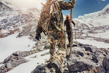 Hiker goes uphill in high mountains
