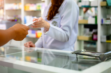 hand of woman phamacist holding prescription of medicine and explain property of medicine to patient or buyer customer how to apply