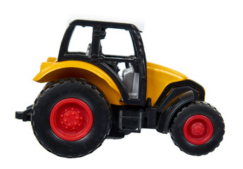 Yellow plastic traktor toy. Farming vehicle, harvest equipment.