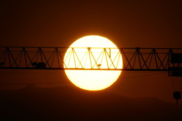crane solar disk sunset disco solar al atardecer con grua de la construccion de edificios