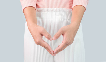 Close up view of young woman and Hand is a symbol of heart over her crotch. Feminine hygiene...