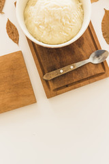 Potato puree in bowl on wooden board