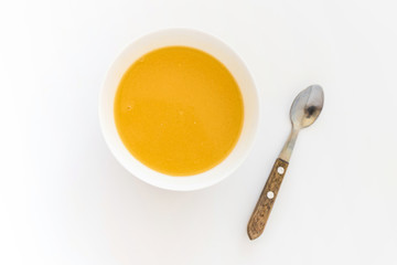 Bowl of pumpkin soup on table