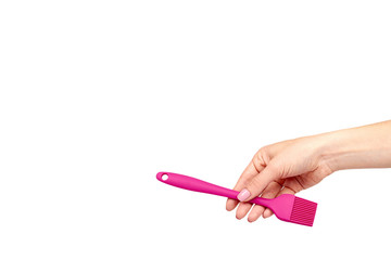 Hand with pink culinary brush, kitchen utensil.