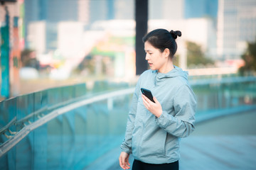 Woman doing warm up and watch on her smartphone