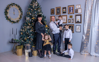 Christmas family. Family celebration. Smart family next to the Christmas tree. Large large family assembly. New Year holiday. Dressed up Christmas tree.