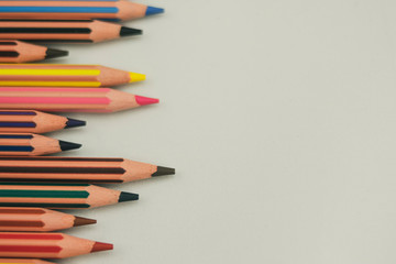 Colored pencils on the left on white background