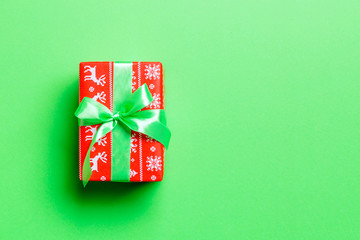 Top view Christmas present box with green bow on green background with copy space