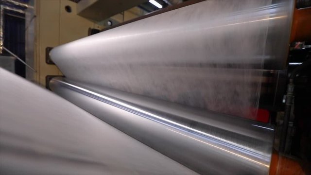 Rolls of non-woven fabric are being pushed into the tube. Nonwoven fabric production