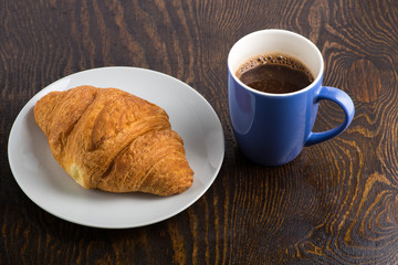 croissant on a white plate and coffee in a purple mug
