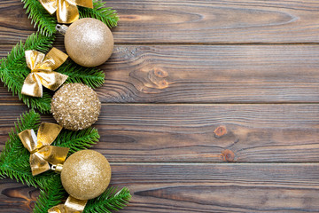 Fototapeta na wymiar Set of festive balls, fir tree and Christmas decorations on wooden background. Top view of New Year ornament concept with copy space