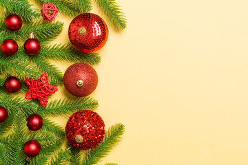 Christmas composition made of fir tree, balls and different decorations on colorful background. Top view of New Year Advent concept with empty space for your design