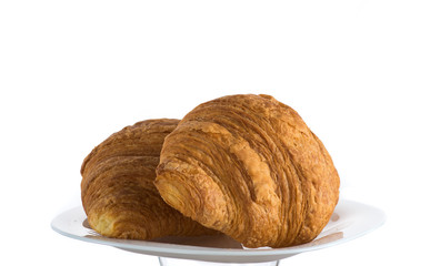 two croissants on a white plate on a white background