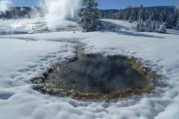 Melted snow around hot thermal lake in Yellowstone, United States