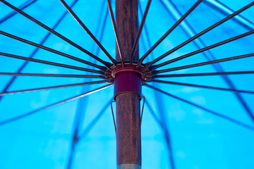 Close up view of the inside of an open, blue umbrella.