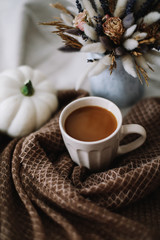 Coffee cup with flowers and pumpkins on a cozy plaid. Autumn still life. Breakfast in bed. Good morning. Stylish autumn flat lay. 